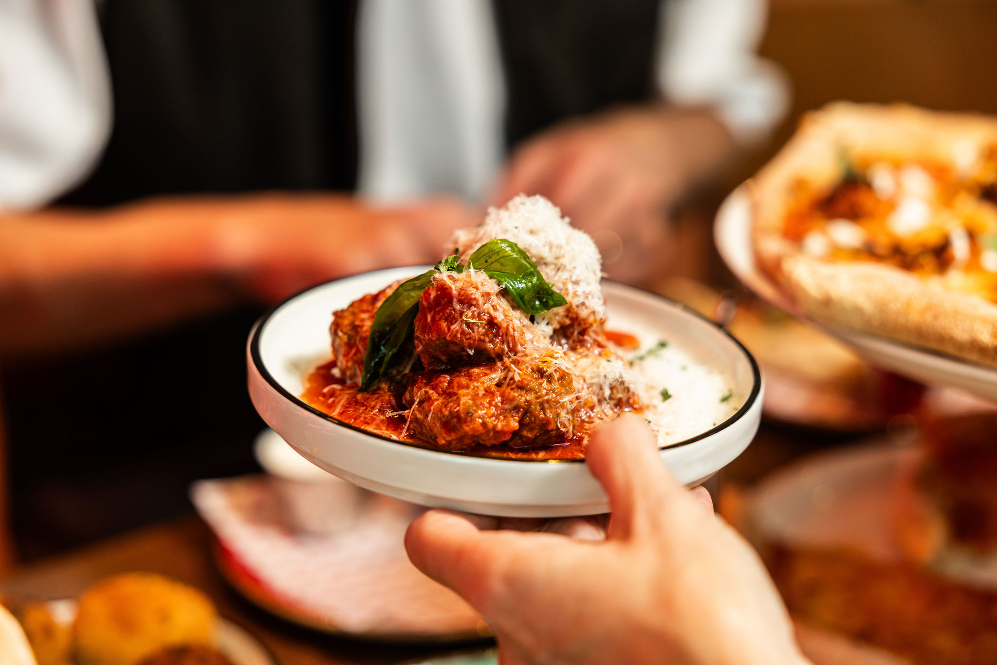 Meatballs in tomato sauce topped with Parmesan and basil, served at Dip Doh Pizza Co.